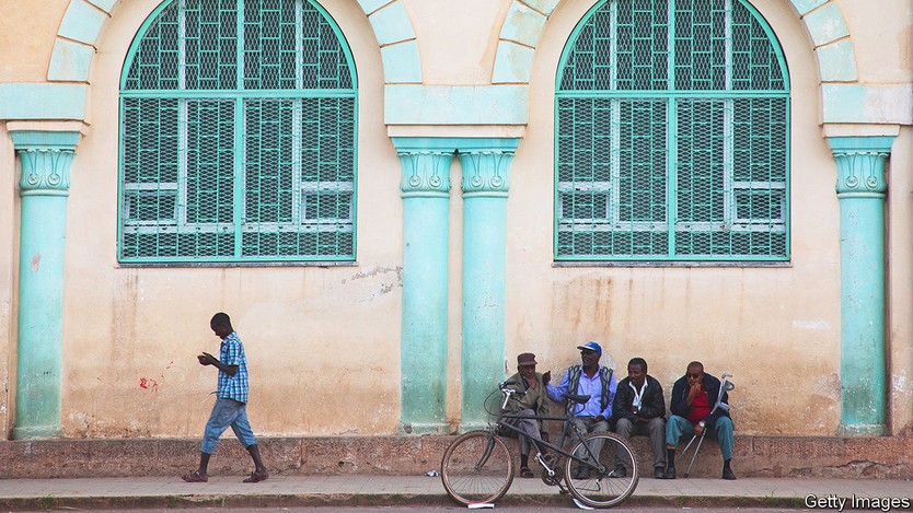 ASMARA, ERITREA - AUGUST 21: Eritrean people in front of a building from the italian colonial times near the mosque, Central region, Asmara, Eritrea on August 21, 2019 in Asmara, Eritrea. (Photo by Eric Lafforgue/Art in All of Us/Corbis via Getty Images)