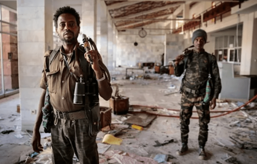 Amhara Fano militia fighters walk in the terminal at Lalibela airport